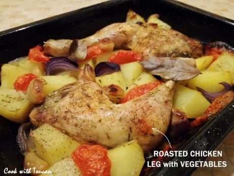 Roasted chicken legs with potatoes, tomatoes and red onion